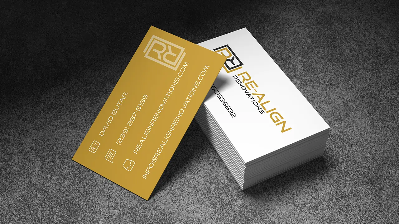 Re-Align Renovations business cards for co-owner David Butar mocked up on a concrete surface.